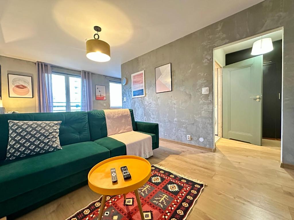 a living room with a green couch and a table at MOMOApart - by Kromera in Wrocław