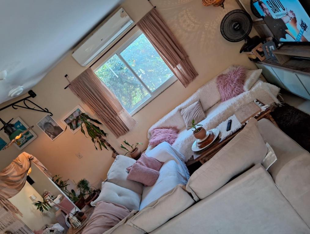 ein Wohnzimmer mit einer Couch und einem Fenster in der Unterkunft Bela e Aconchegante casa em Vargem Grande in Rio de Janeiro