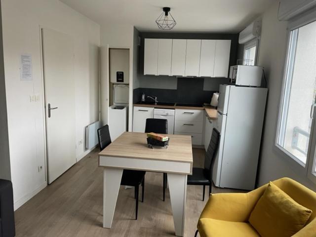 Il comprend une cuisine équipée d'une table et d'un réfrigérateur. dans l'établissement Leclerc 217, à La Roche-sur-Yon