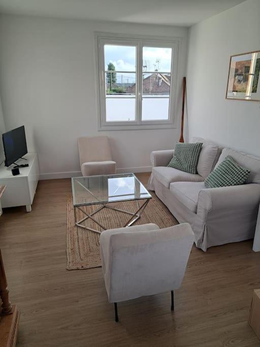 un salon avec un canapé et une table dans l'établissement Maison de bord de mer à Hermanville-sur-mer, à Hermanville-sur-Mer