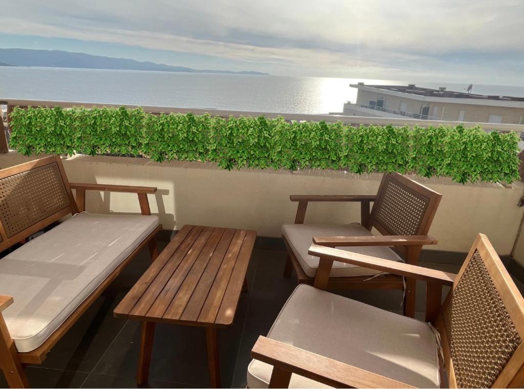 - deux bancs et des chaises sur un balcon donnant sur l'océan dans l'établissement Grand T2 Ajaccio proche Casone, à Ajaccio