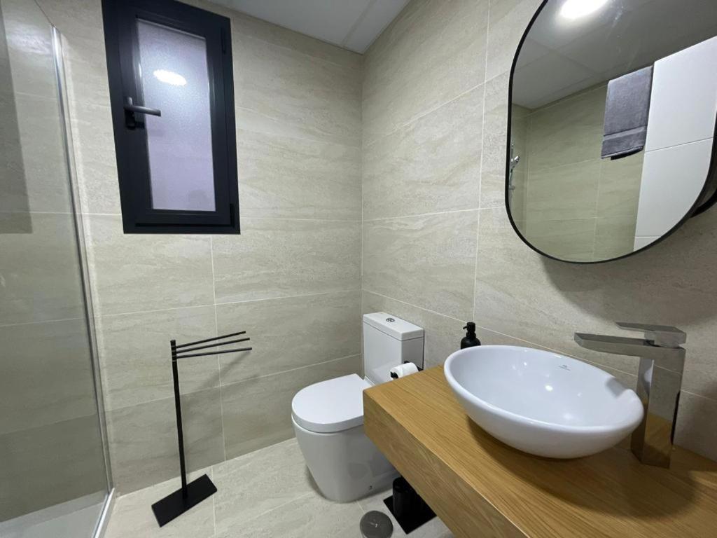a bathroom with a sink and a mirror and a toilet at LHOME CÁDIZ in Cádiz