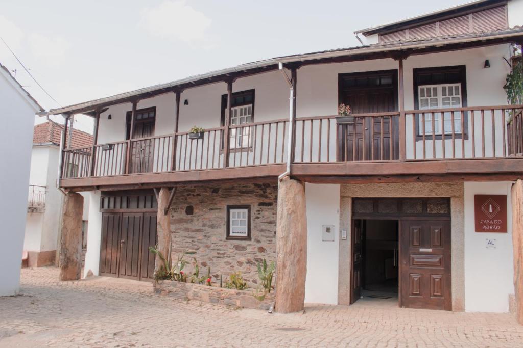 an old stone building with a balcony on top at Casa Do Peirão in Varge