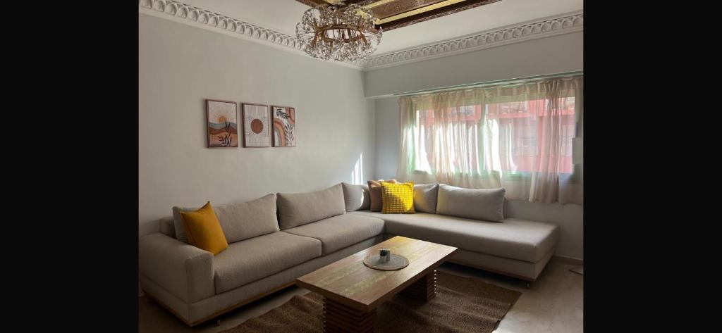 a living room with a couch and a coffee table at Bel Appartement meublé avec Piscine, l'hivernage à Marrakech in Marrakech