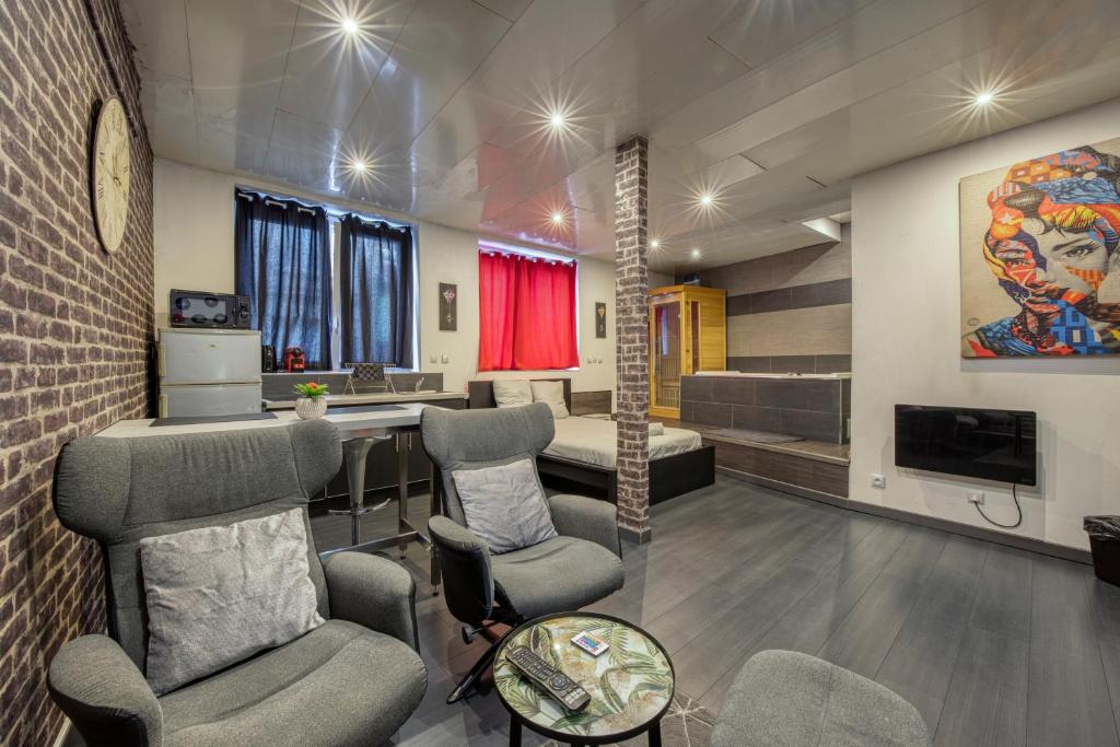 Una sala de espera con sillas, una mesa y un televisor. en street Loft with sauna, en Saint-Étienne