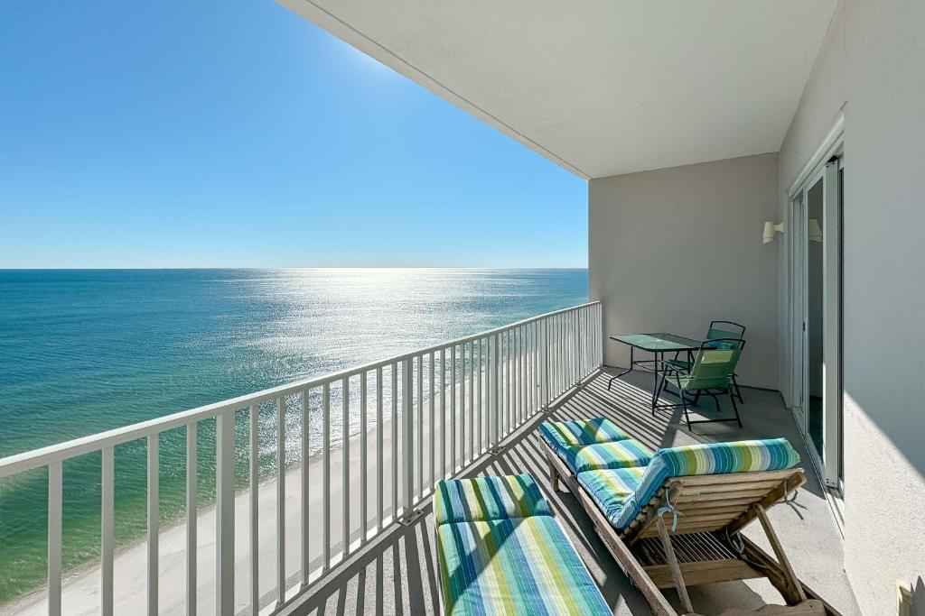 een balkon met stoelen en een tafel en de oceaan bij Windemere Unit 1505 in Pensacola