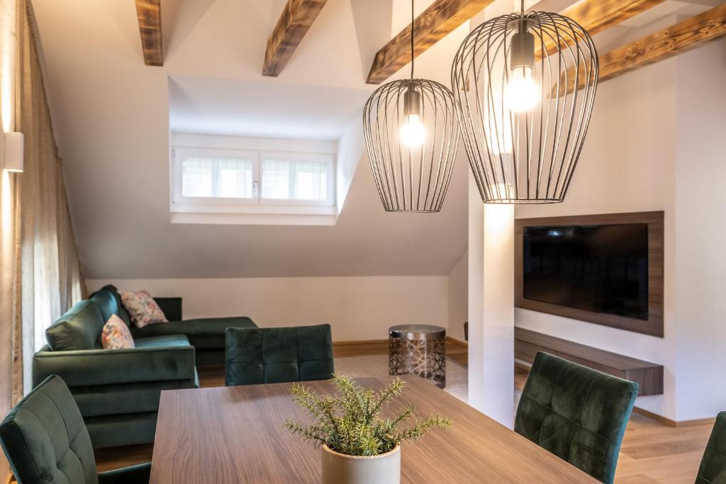 a living room with a table and chairs and two chandeliers at Odilia - Historic City Apartments - center of Brixen in Bressanone