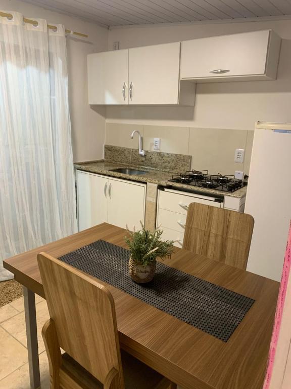 a kitchen with a wooden table and a kitchen with white cabinets at Mar Azul A&K - Sol e Mar in Penha