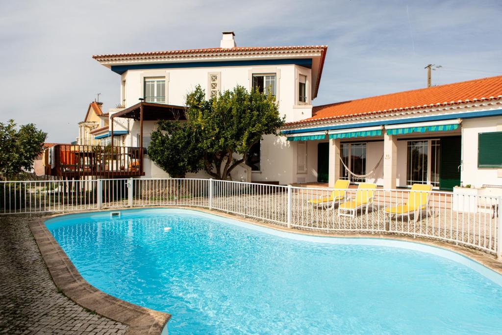 a swimming pool in front of a house at Casa do Limoeiro in Praia da Areia Branca