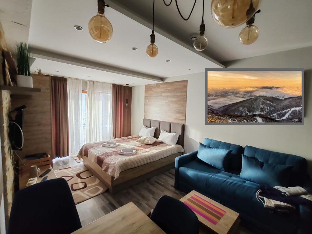 a bedroom with a bed and a blue couch at Ogi & Una Premijer 42 in Kopaonik
