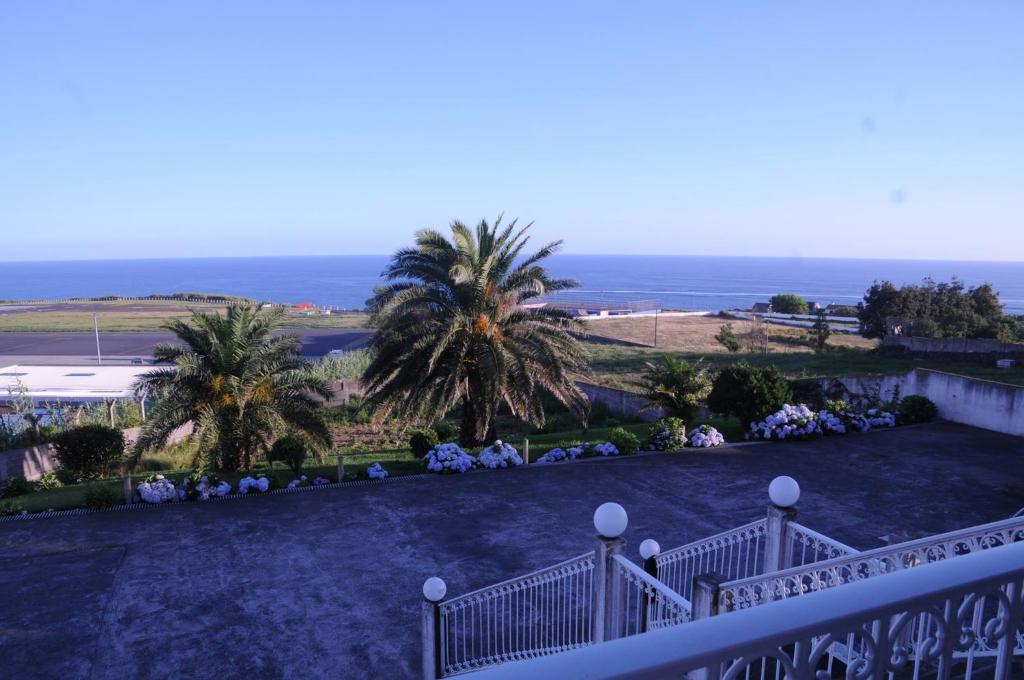 uma vista a partir da varanda de uma casa com palmeiras em Villarelva em Ponta Delgada