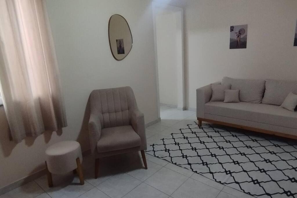 un salon avec un canapé et une chaise dans l'établissement Apartamento ACOLHEDOR, à Rio de Janeiro