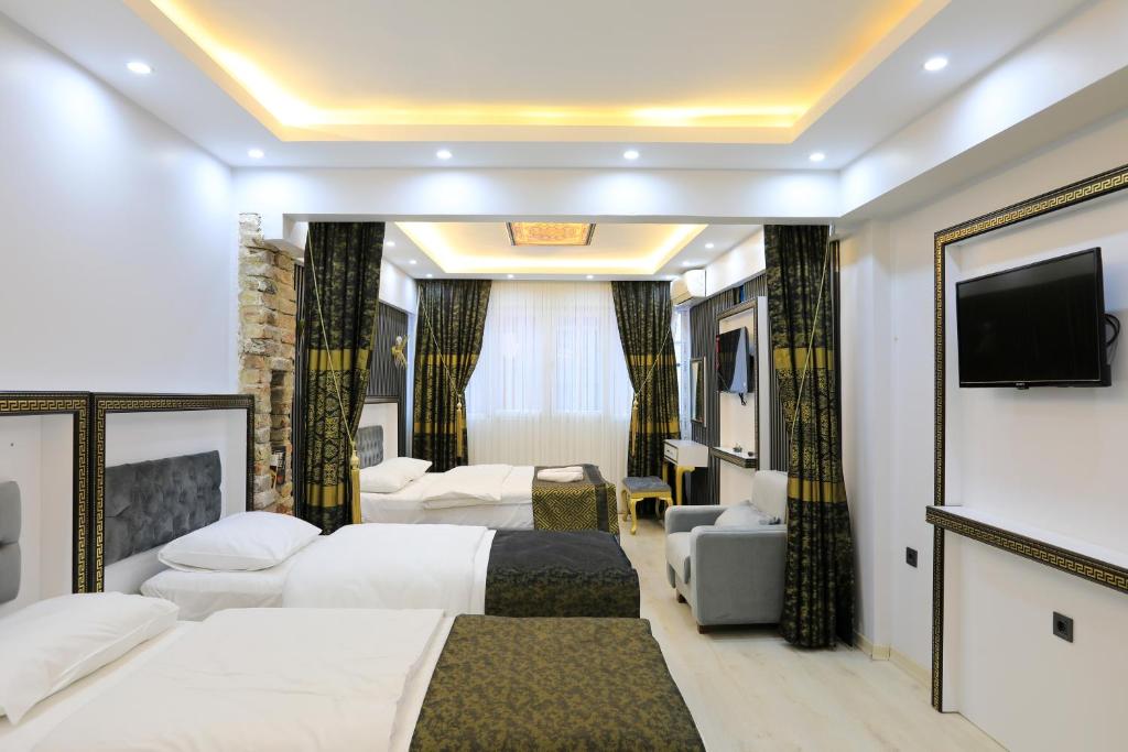 a hotel room with two beds and a flat screen tv at Istanbul Hotel&Guesthouse in Istanbul