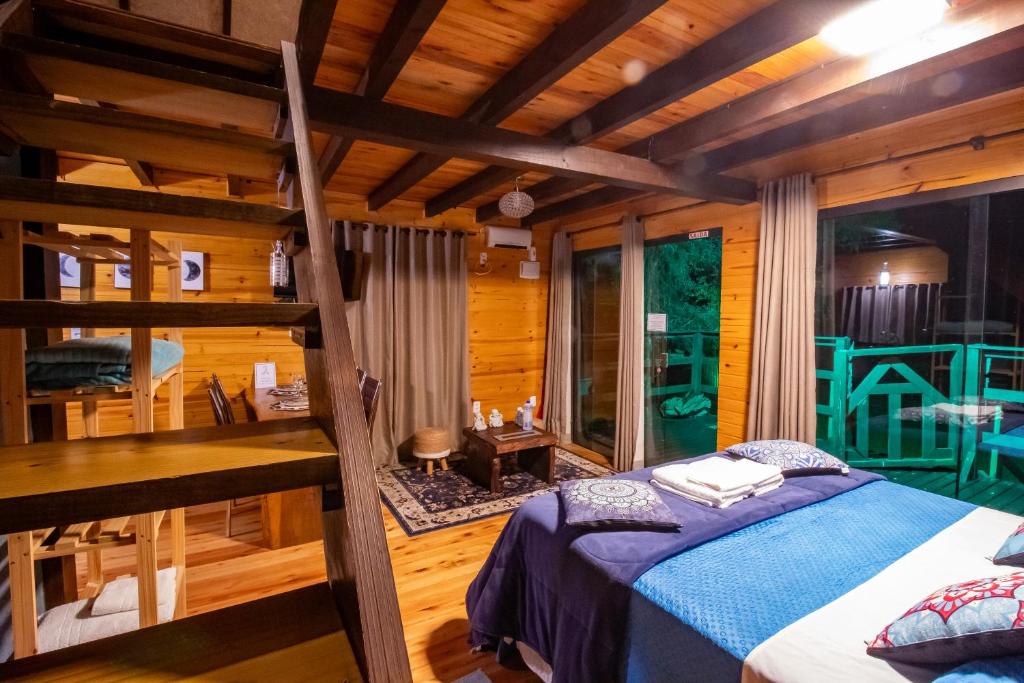 a bedroom with a bed and a desk in a room at Pousada Jardim do Buda com Café e Piscina in Urubici