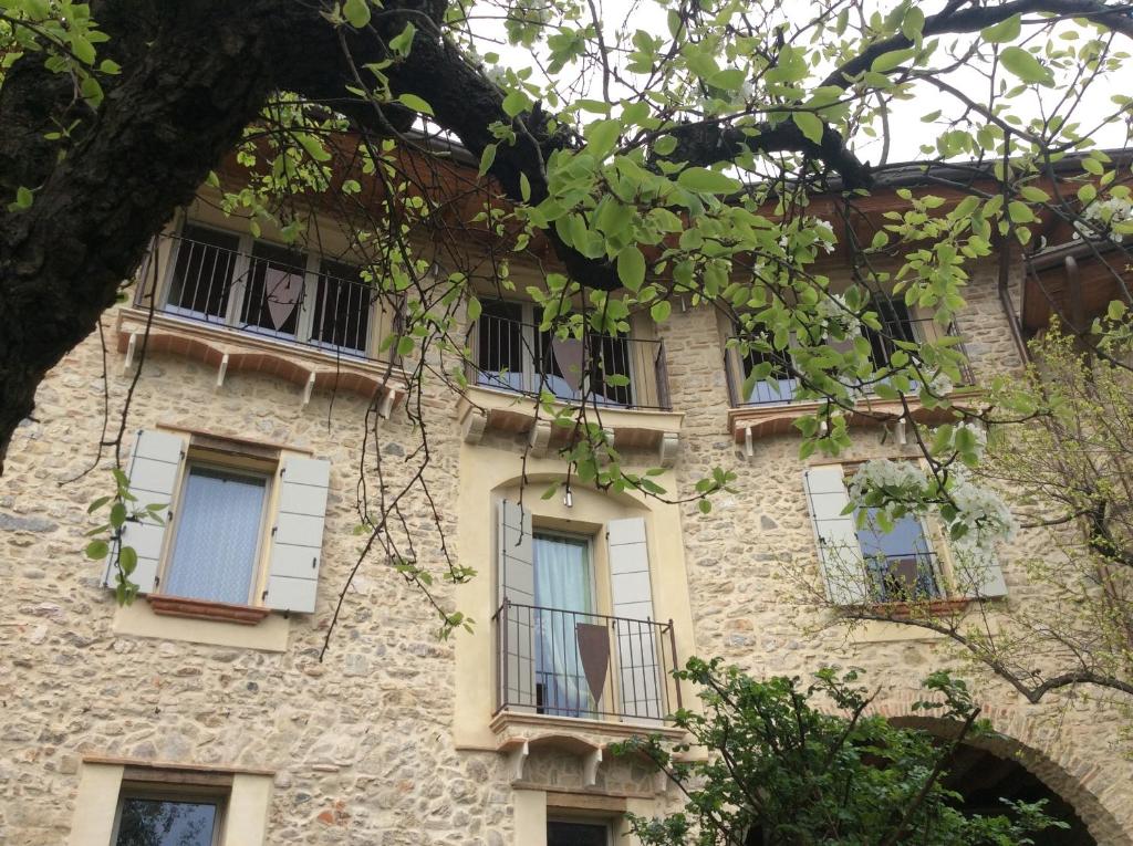VobarnoにあるB&B Locus Amoenusの白窓と木が特徴の古い石造建築