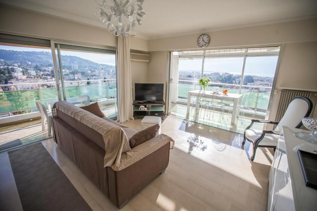 salon z kanapą i dużym oknem w obiekcie Central Park Apartments by Connexion w Cannes