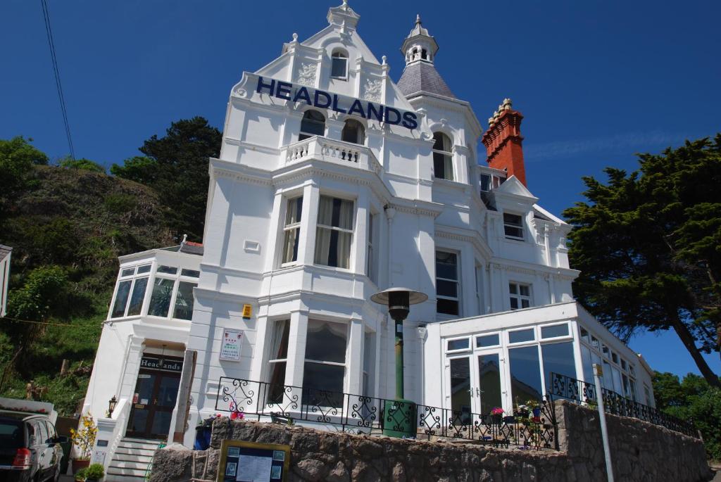 Ein weißes Gebäude mit einem Schild drauf. in der Unterkunft Headlands Hotel in Llandudno