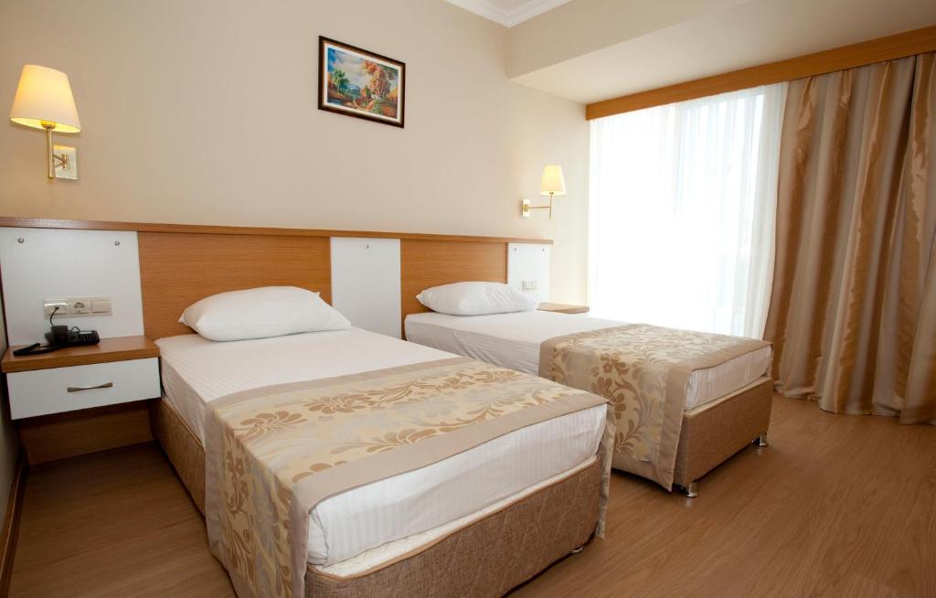 Postel nebo postele na pokoji v ubytování Aes Club Hotel