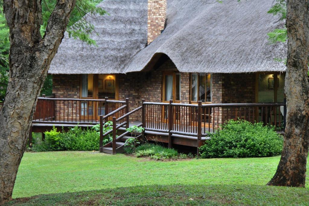 ein großes Backsteinhaus mit einem Strohdach in der Unterkunft Kruger Park Lodge Unit No. 243 in Hazyview