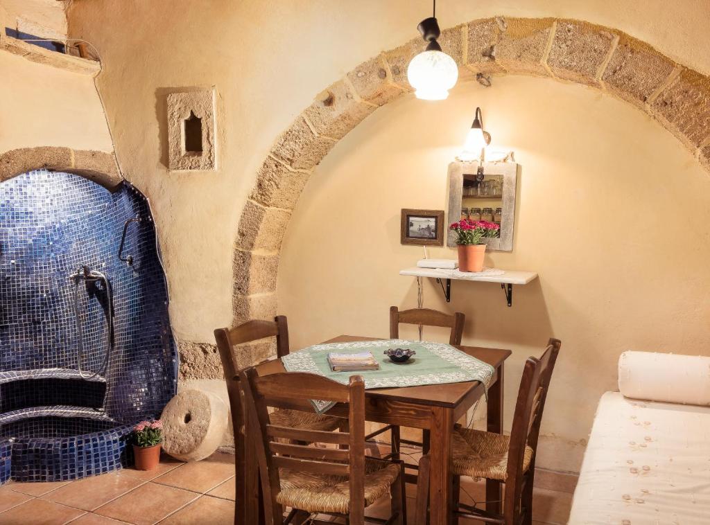 a dining room with a table and chairs in a building at Old Stone House in Chania Town