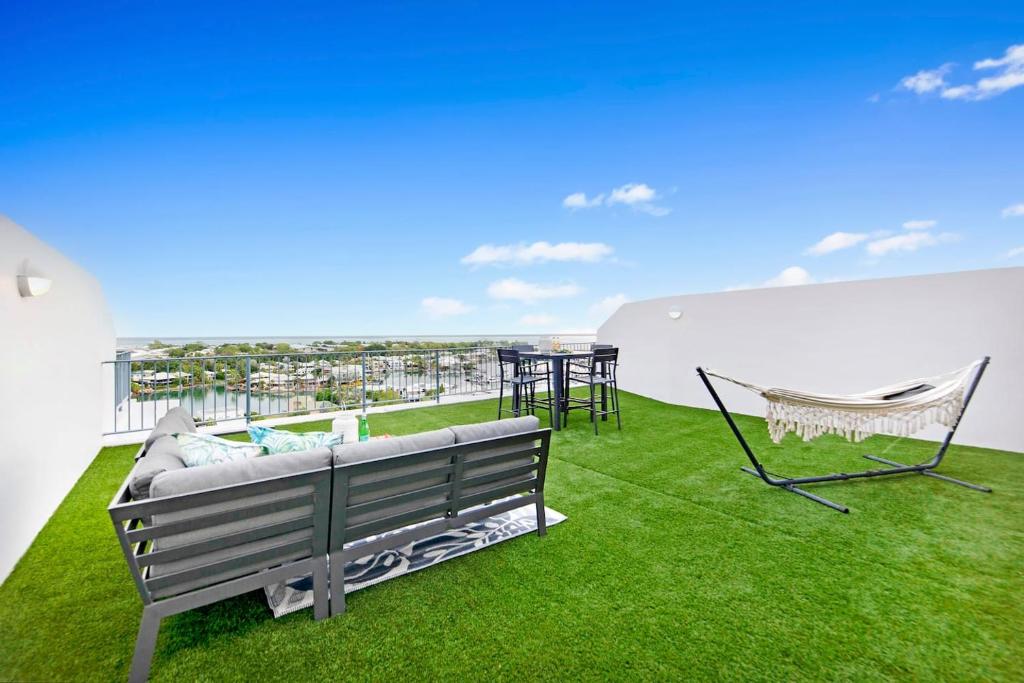 a balcony with a bench and a table and chairs at Sunset Penthouse - Unique Panoramic Rooftop Retreat in Larrakeyah