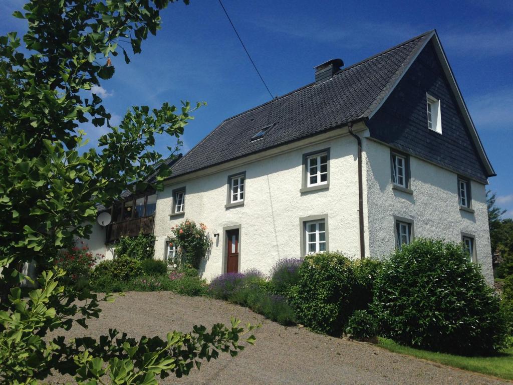 una casa blanca con techo negro en Historical Apartment, en Gummersbach