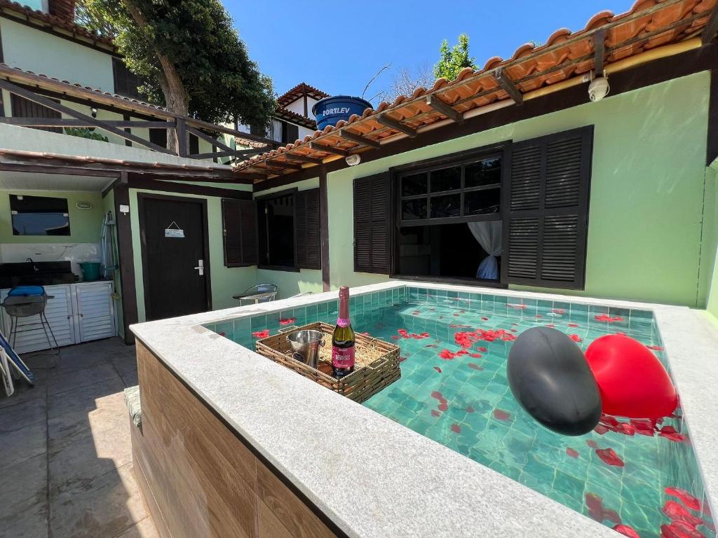 Casa aconchegante a 7 min da Praia في بوزيوس: مسبح وزجاجة من النبيذ فيه