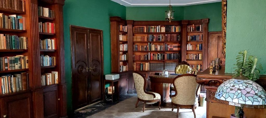 biblioteca con librerie in legno, tavolo e sedie di Residencia Casa del Roble 1 a Cuernavaca