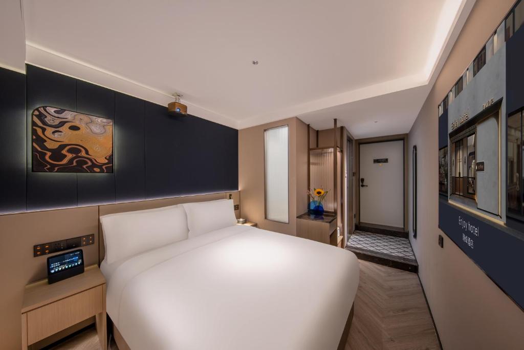 Postel nebo postele na pokoji v ubytování Enjoy Hotel - Provide free late night supplies,free fruit,water and free breakfast coffee,Near Beijing Embassies,Agricultural Exhibition Hall,Sanlitun,Metro line 10 Tuanjiehu,CBD,CCTV,China Zun
