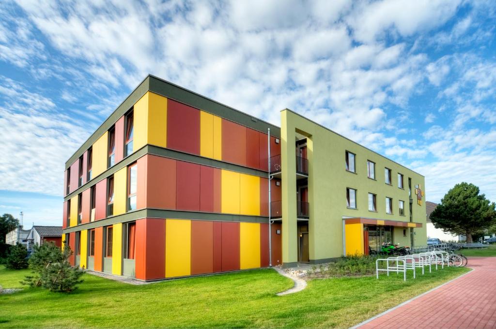 a building with a colorful facade on a lawn at Haus 54 in Zingst