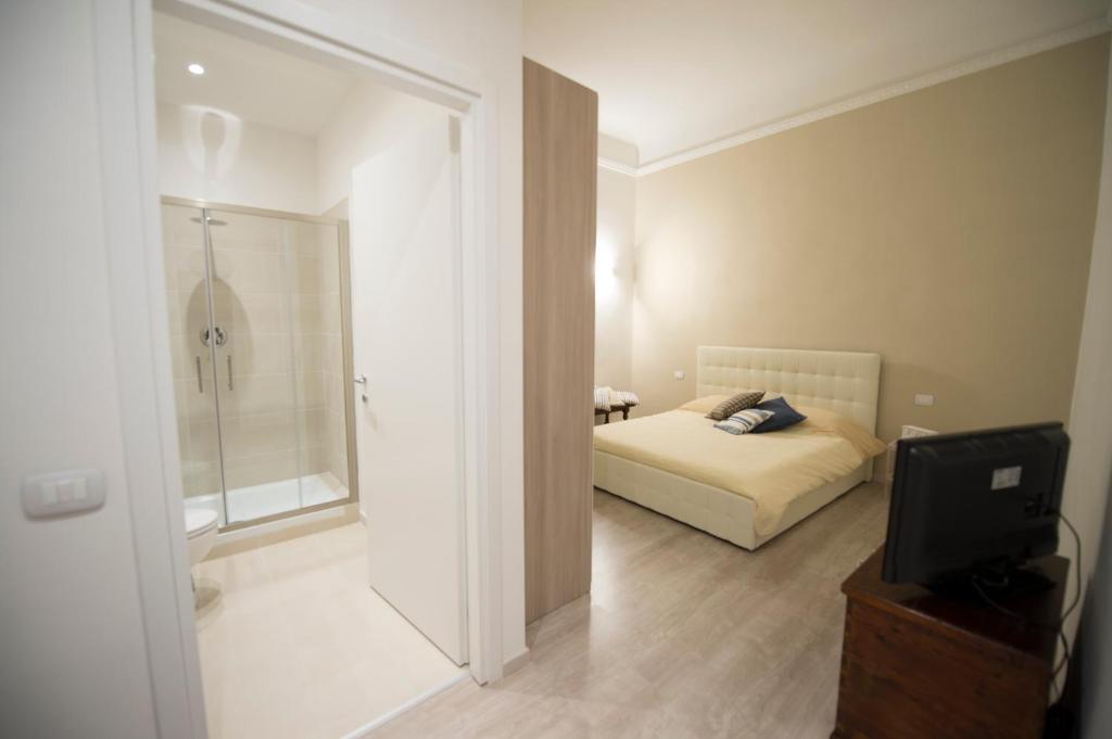 um quarto com uma cama, um chuveiro e uma televisão em La Filarocca B&B em Florença