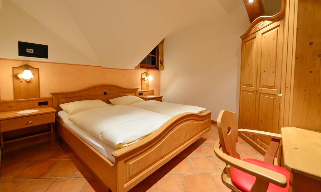 Schlafzimmer mit einem Bett, einem Schreibtisch und einem Stuhl in der Unterkunft Bruneggerhof in Weißenbach
