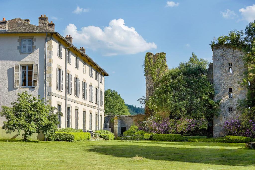 un gran edificio blanco con dos torres en un patio en Abbaye du Palais en Thauron