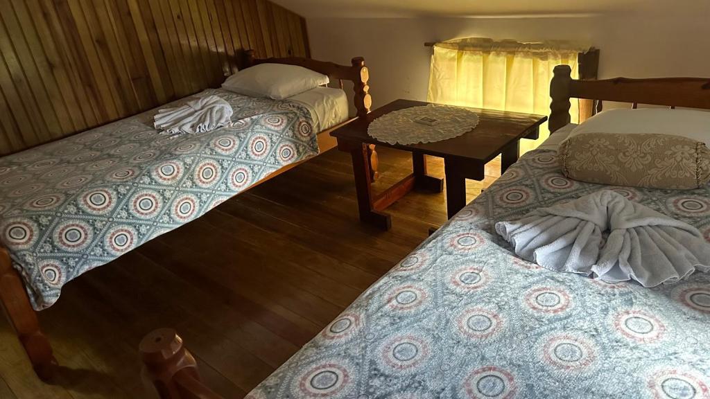 a room with two beds and a table with a table at Hotel Caribbean View in Bastimentos