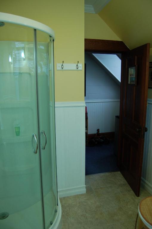 a glass shower in a room with a staircase at The Yellow Sidecar B&B in Cap Le Moine