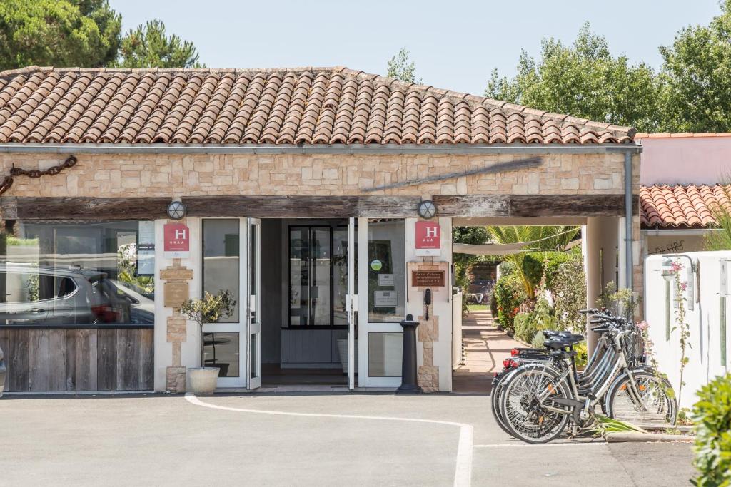 a group of bikes parked outside of a building at Hôtel Restaurant & Spa Plaisir in Le Bois-Plage-en-Ré