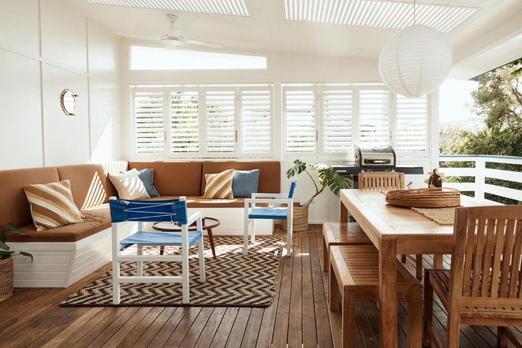 ヤンバにあるBAY PROPERTIES . The Sailors Upper Deckのソファとテーブルと椅子のあるリビングルーム