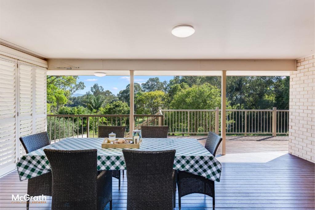 a dining table and chairs on a deck with a view at Sparkling Waters in Toormina