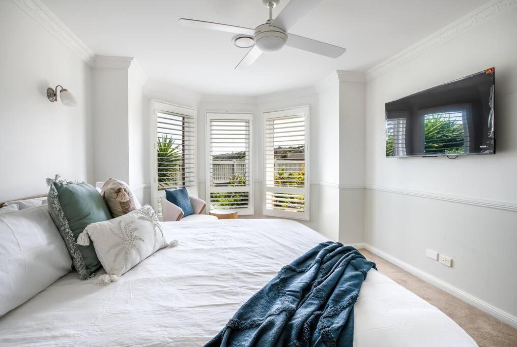 Un dormitorio blanco con una cama y un ventilador de techo. en Spacious Pet Friendly Ping Pong Table, en Ocean Grove
