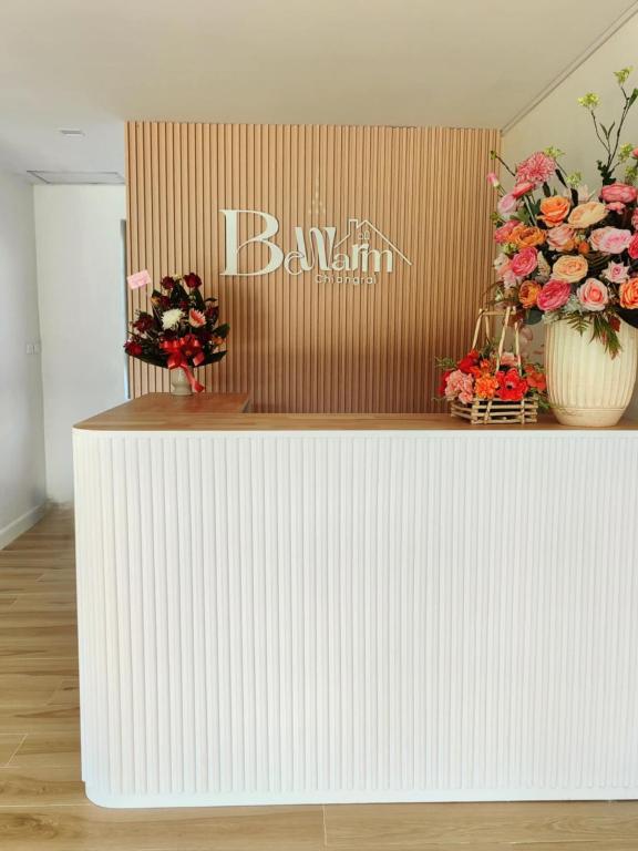 a white counter with two vases of flowers on it at Bewarm บีวอร์ม เชียงราย in Ban San Ton Ko (1)