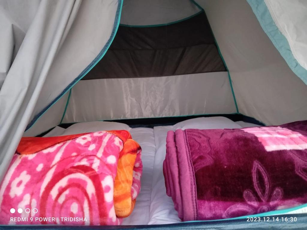 two blankets on a bed in a tent at Fesengbor eco camp in Kāziranga