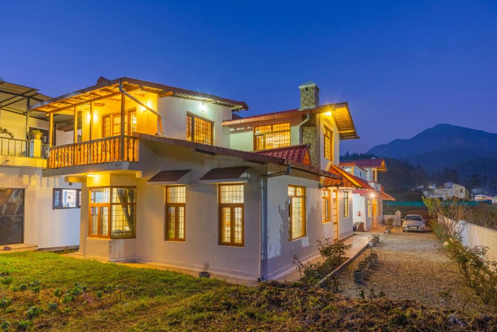 a house with lights on in the night at Alaya Stays 3BHK Rose Haven near Kainchi Dham in Bhowāli