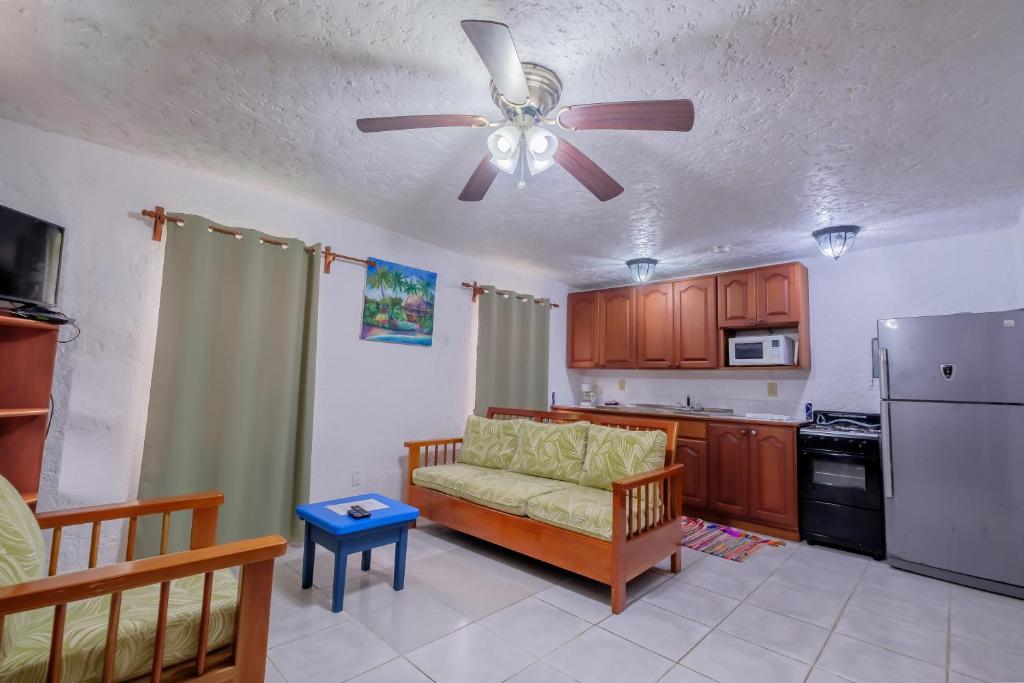 Una sala de estar con un sofá y un ventilador de techo. en Seven Seas Resort Adults Only, en San Pedro