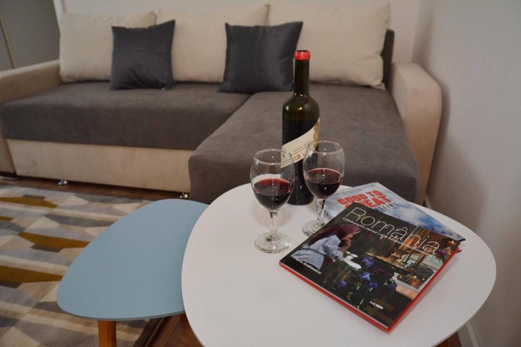 a table with a bottle of wine and two glasses at SMP Apartment in Timişoara