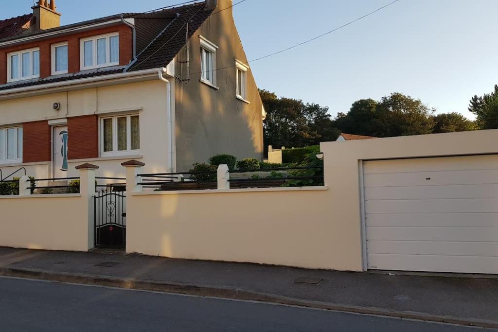 une maison avec une clôture blanche et un garage dans l'établissement SEJOUR en OPALE WISSANT, à Wissant