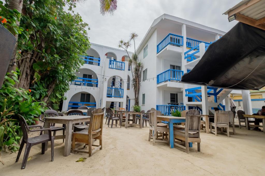Un restaurante con mesas y sillas frente a un edificio. en Seven Seas Resort Adults Only, en San Pedro