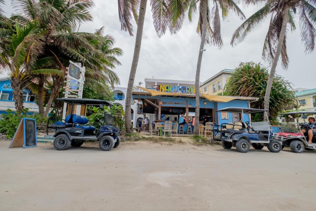 dos carros de golf estacionados frente a un edificio en Seven Seas Resort Adults Only, en San Pedro