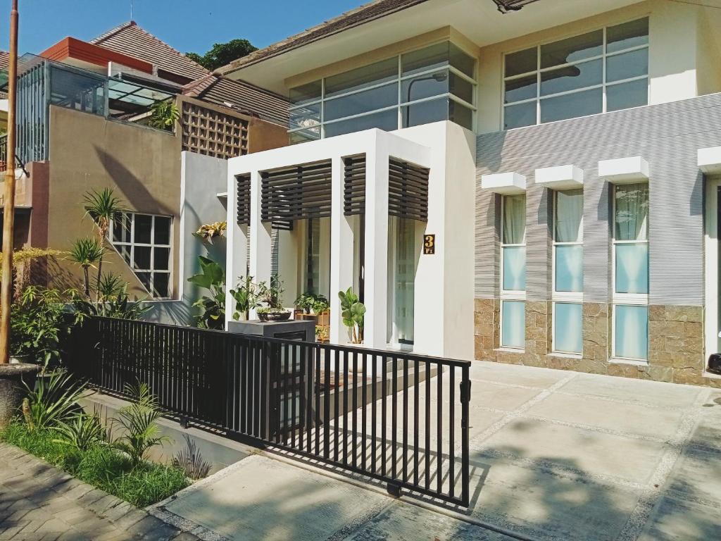 a house with a black fence in front of it at The Icon Homestay Malang in Blimbing
