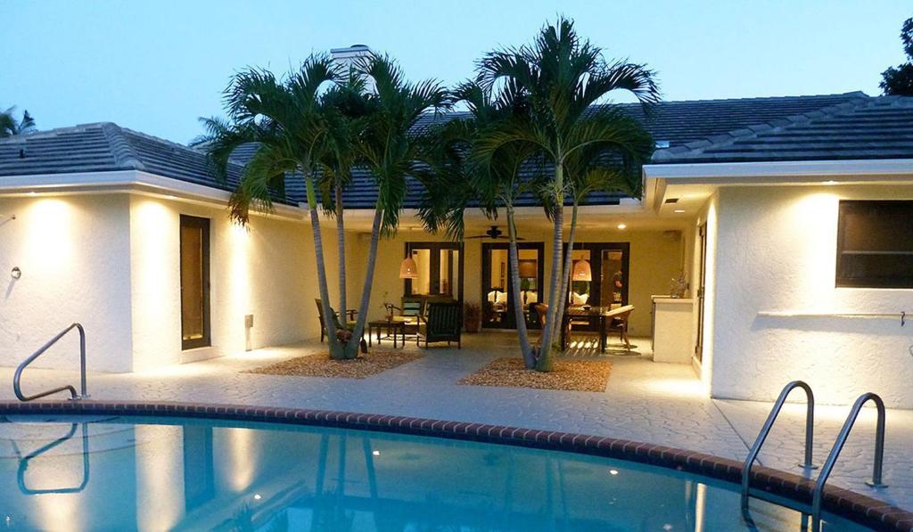 a house with a swimming pool in front of a house at Dolphin Retreat - East Boca Raton in Boca Raton