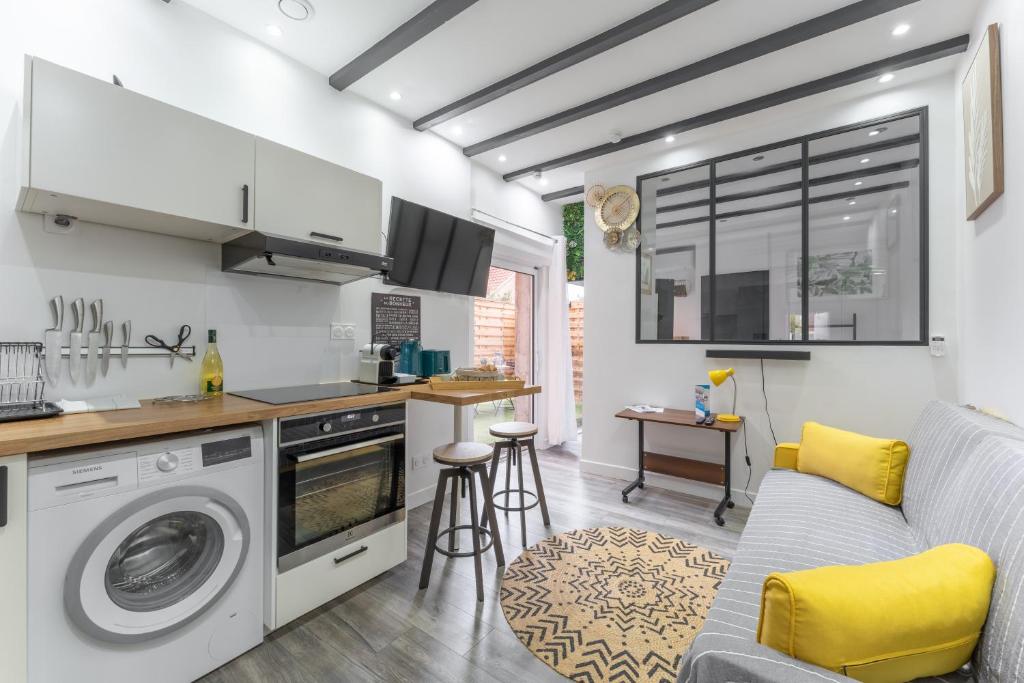 a kitchen and living room with a washer and dryer at Le Petit Enclos - Appt climatisé parking privé in Vaulx-en-Velin